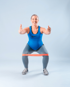 Pregnant women in blue using bands to workouts